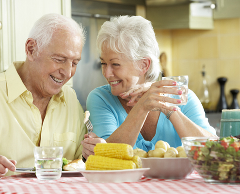 Senior Couple Eating Meal Together In Kitchen