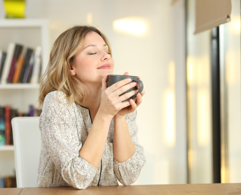 Woman breathing holding a coffee mug at home